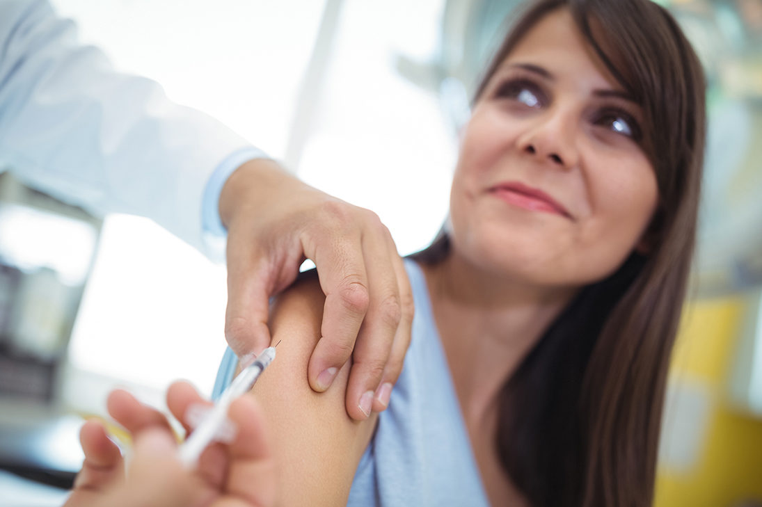Medico inietta il vaccino contro l'influenza a una paziente