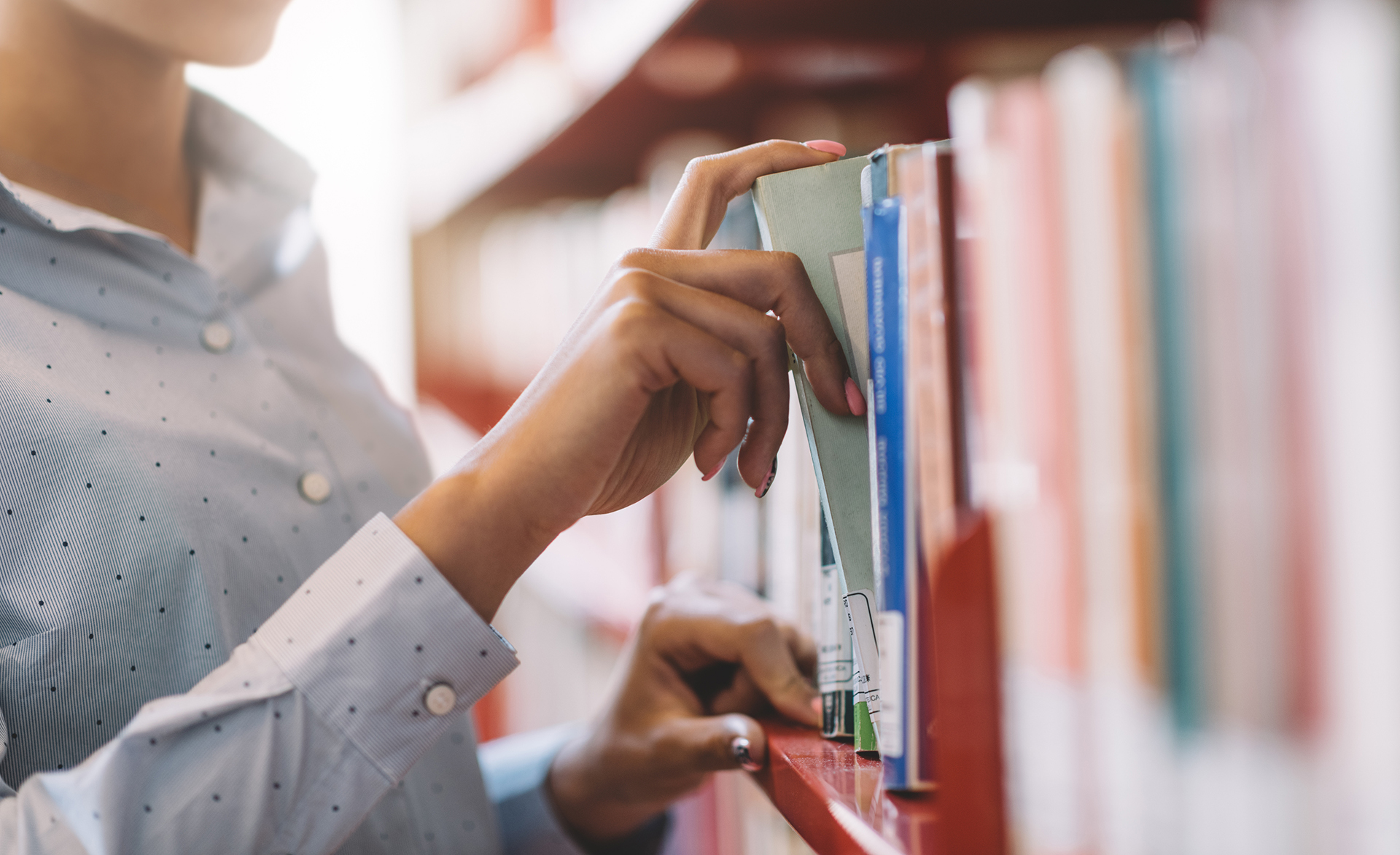 Ragazza in biblioteca cerca un libro