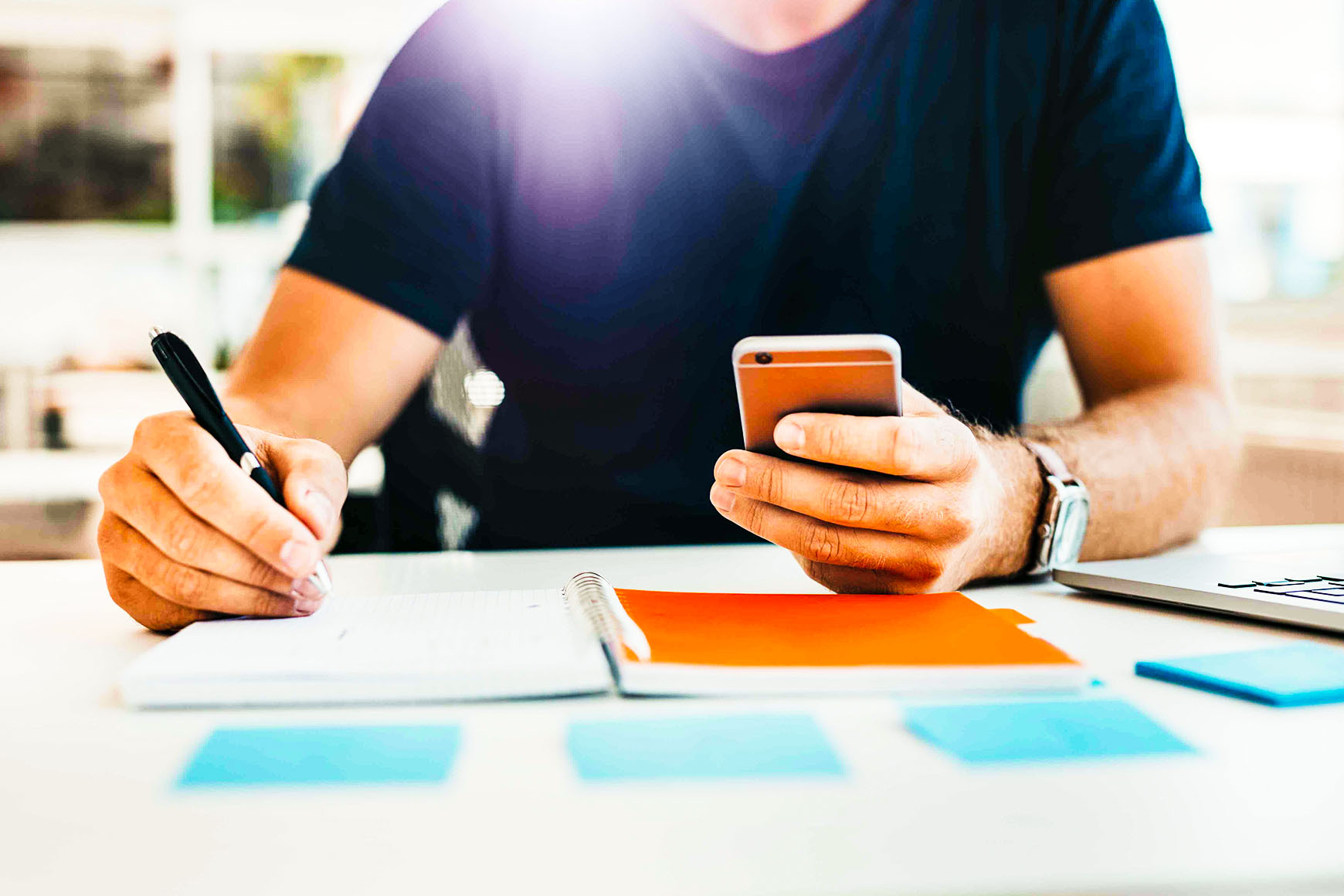 Uno studente alla scrivania di casa con lo smartphone