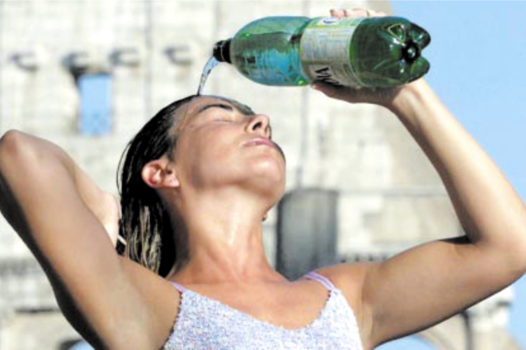 Ragazza si rovescia una bottiglia d'acqua in testa per il caldo