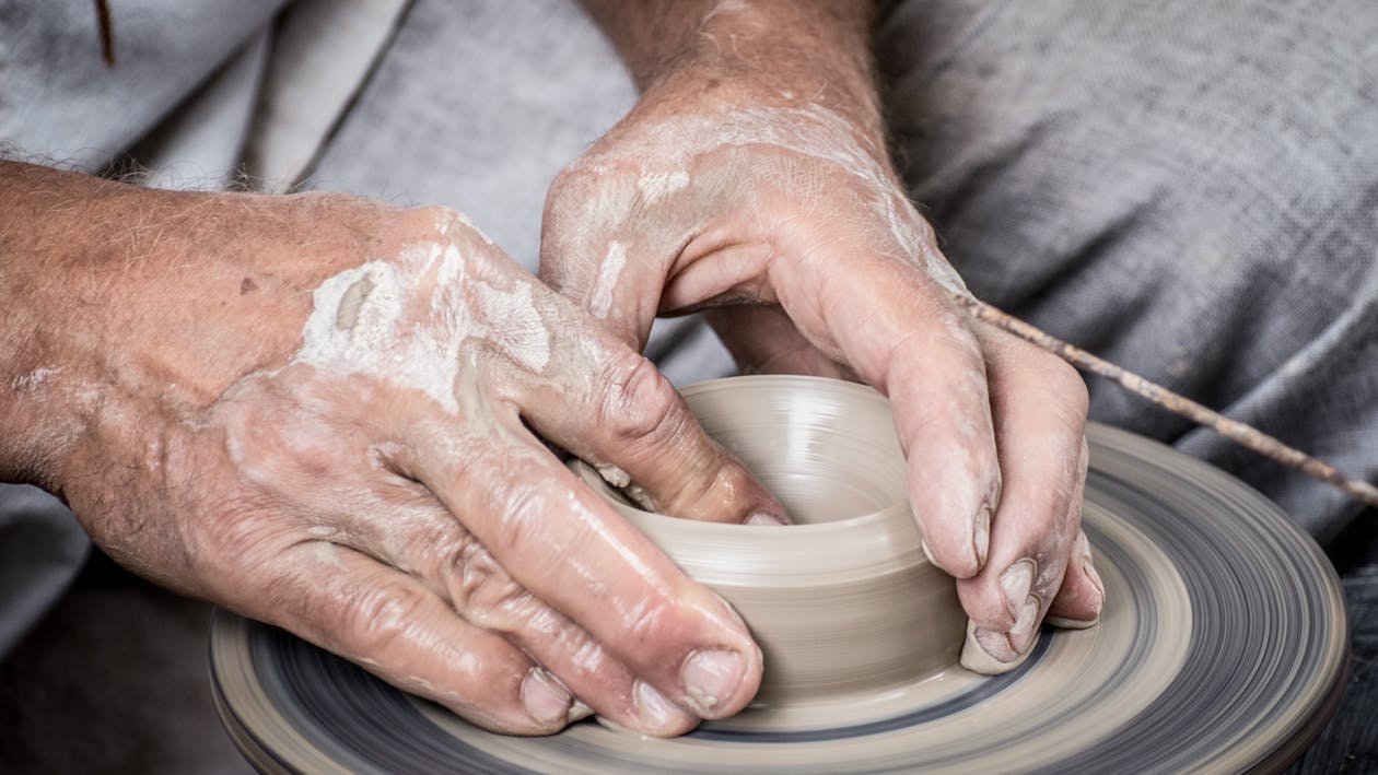 Mani su un vaso in terracotta in produzione