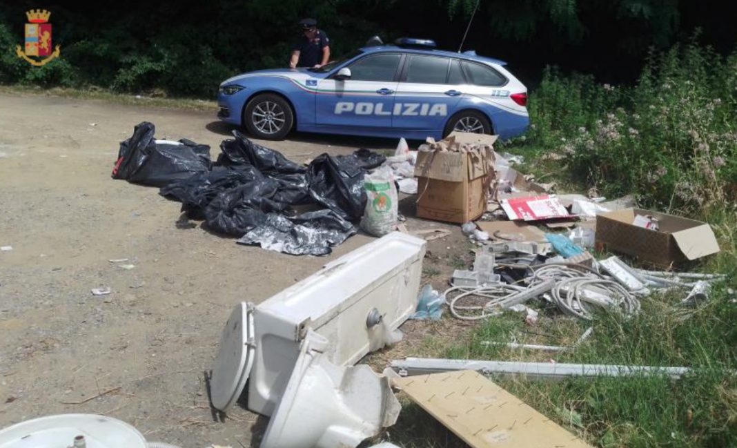 I rifiuti scaricati sulla strada per Acquerino e una macchina della polizia