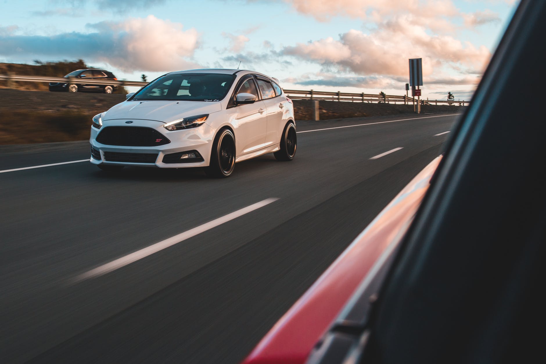 white car driving on asphalt freeway