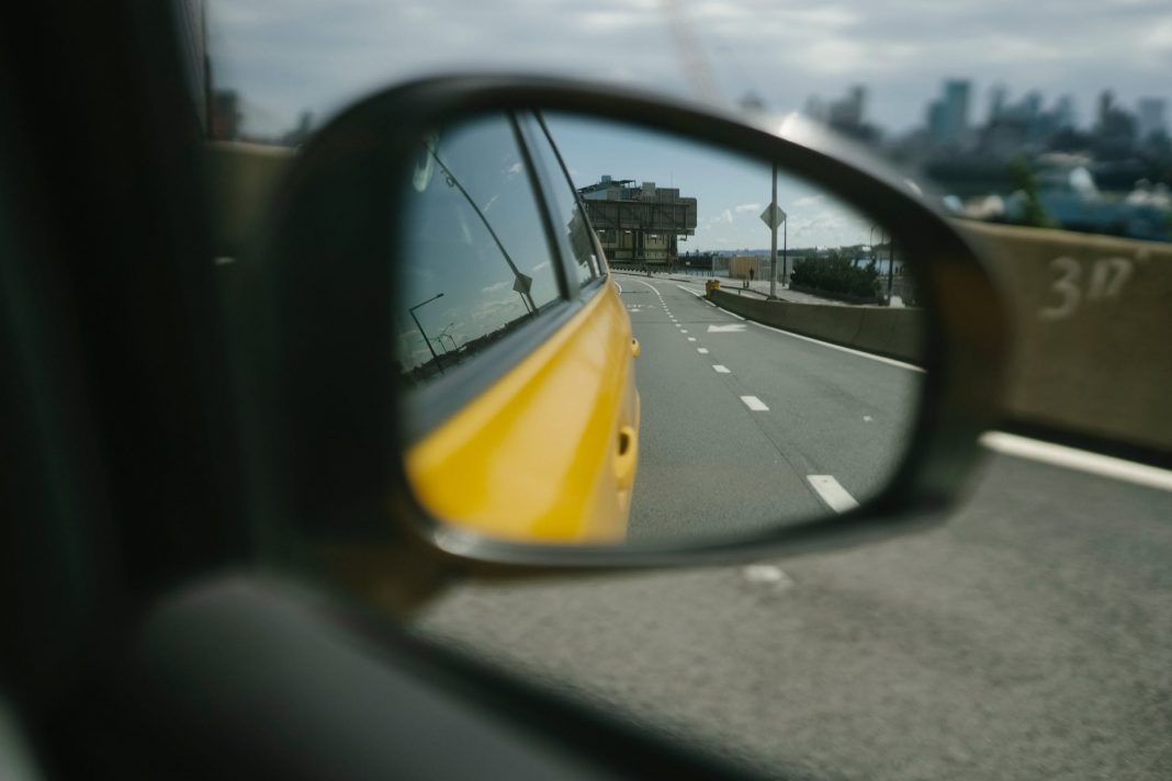reflection of city road in side mirror