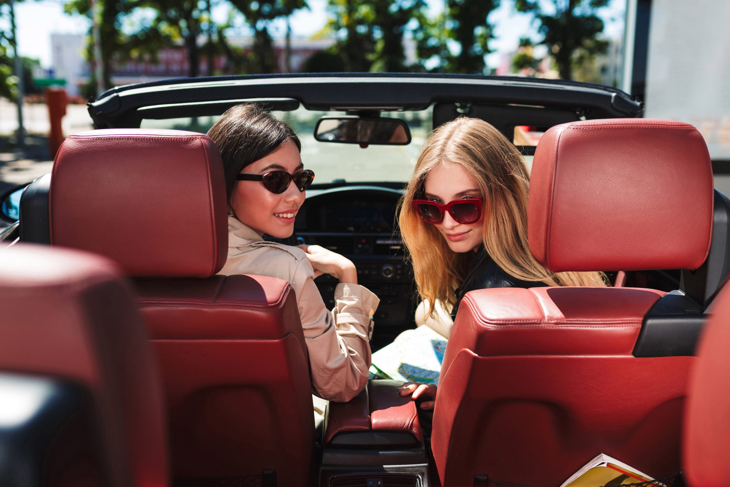 beautiful girls in sunglasses happily looking in camera spending