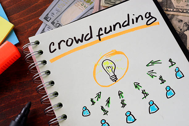 notebook with crowd funding sign on a table. business concept.